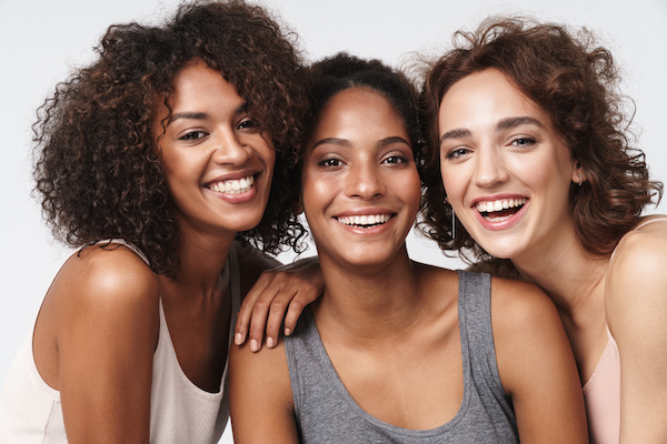 Image of three smiling, ethnically diverse women
